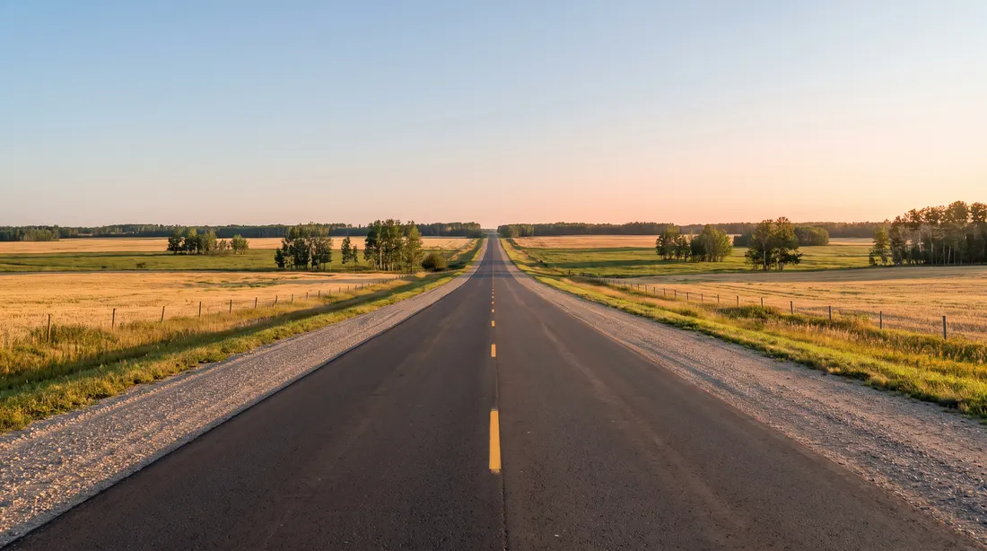 Straight two-lane highway through flat farmland